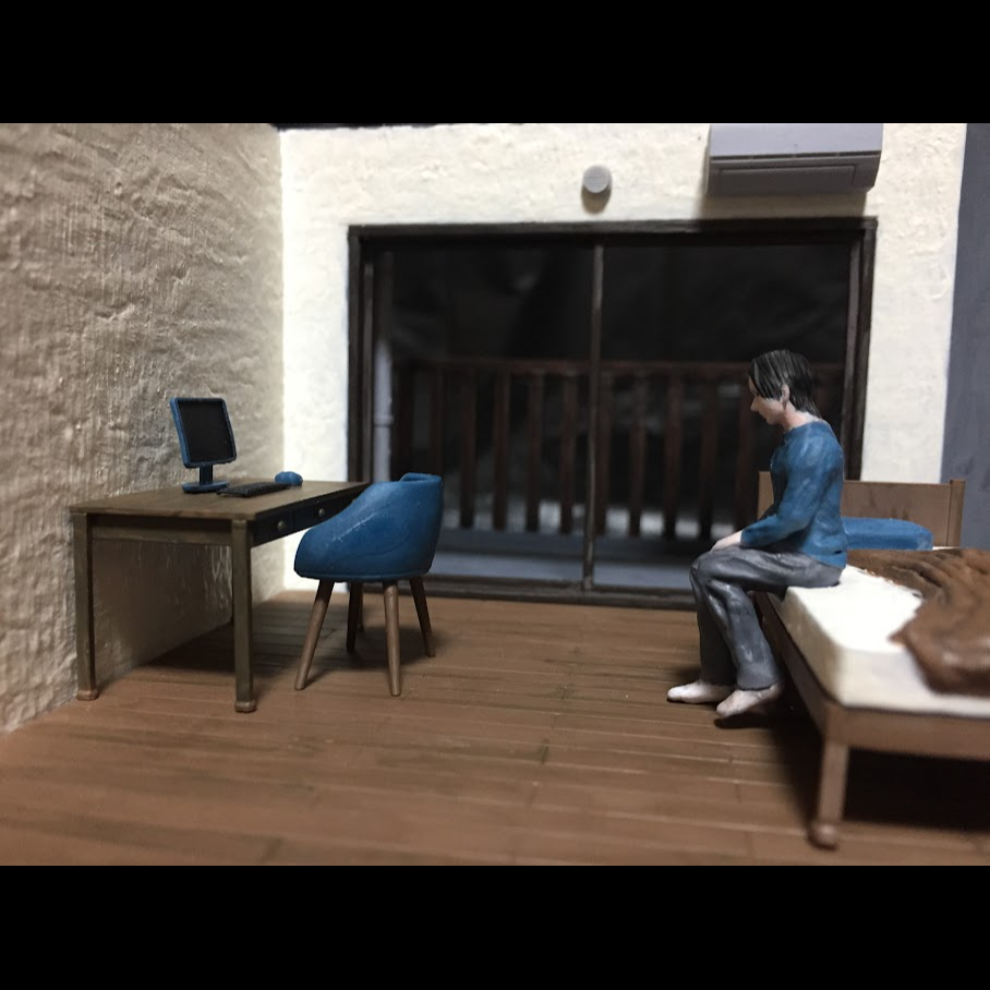 ベッドに腰掛ける男性